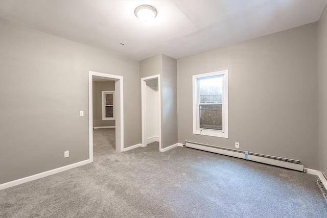 empty room featuring a baseboard radiator, carpet flooring, and baseboards