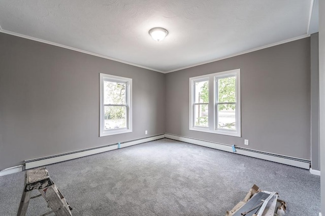 carpeted spare room with a baseboard heating unit, baseboards, and crown molding