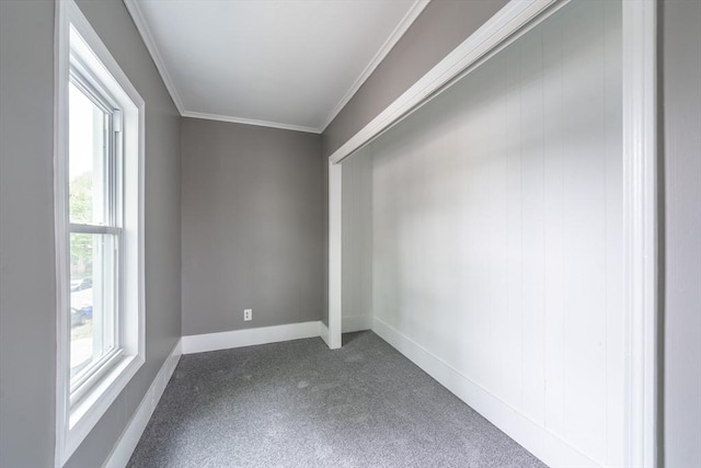 empty room featuring baseboards, ornamental molding, plenty of natural light, and carpet