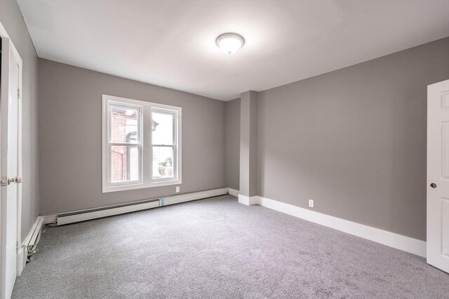 empty room with a baseboard radiator, carpet floors, and baseboards
