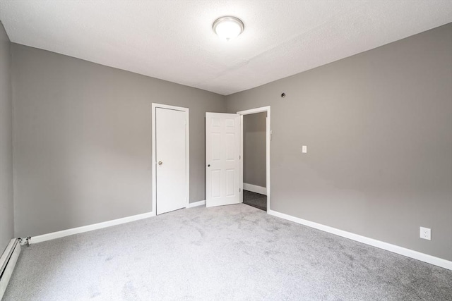 unfurnished bedroom featuring baseboards, baseboard heating, and carpet floors