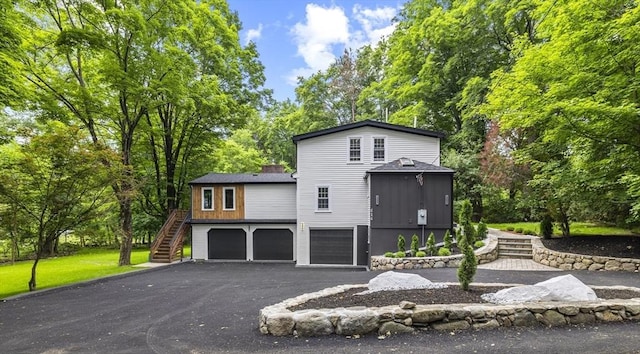 616 Grove St, Framingham, MA 01701 - view of front of home with stairway, a garage, driveway, and view of scattered trees