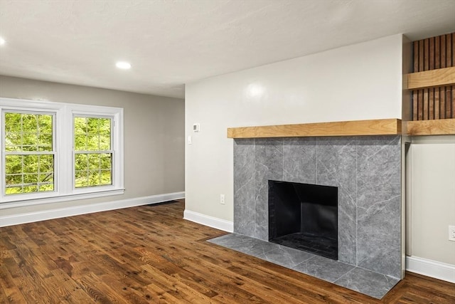 616 Grove St, Framingham, MA 01701 - detailed view of a tiled fireplace, wood finished floors, and recessed lighting