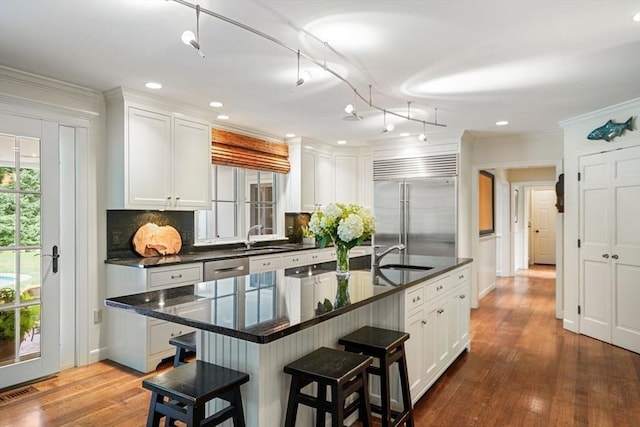 10 Queen Anne Rd, Hopkinton, MA 01748 - kitchen featuring decorative backsplash, a breakfast bar, dark wood-style flooring, stainless steel built in refrigerator, and white cabinetry