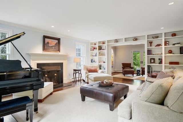 10 Queen Anne Rd, Hopkinton, MA 01748 - living area featuring a fireplace with raised hearth, built in shelves, a baseboard heating unit, wood finished floors, and ornamental molding