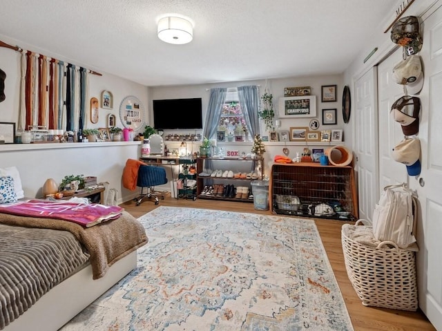 bedroom with wood finished floors and a closet