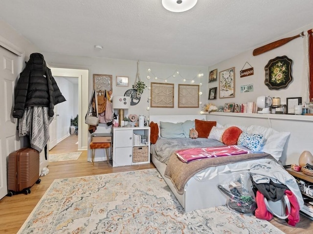 bedroom with wood finished floors and a textured ceiling