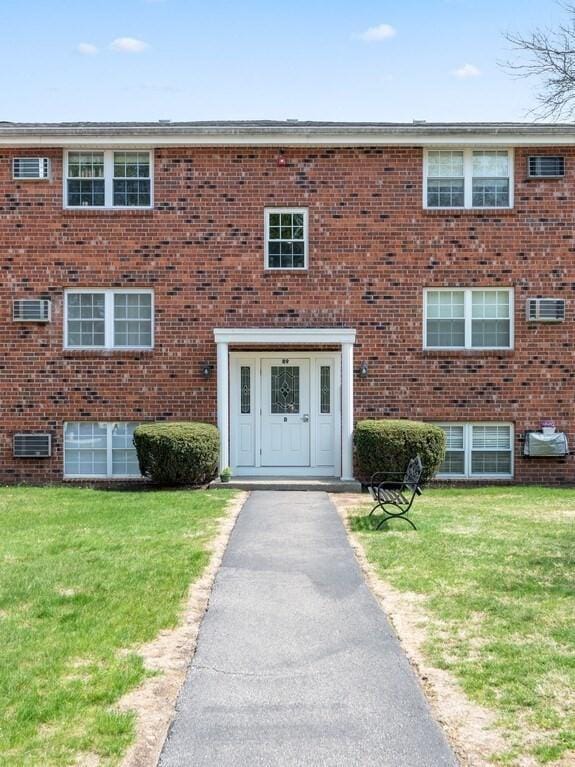 view of property with a front lawn and brick siding