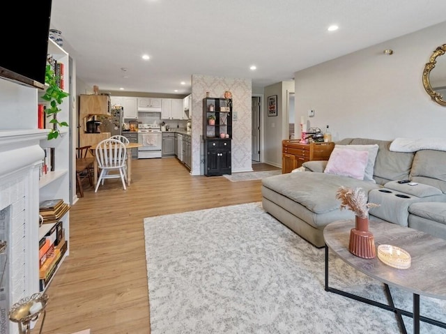 living area featuring light wood-style flooring and recessed lighting