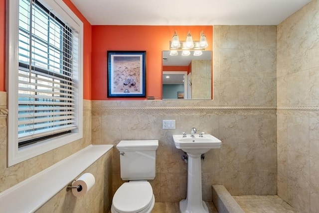 bathroom featuring toilet and tile walls