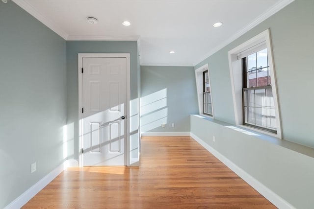 spare room with light wood-style floors, baseboards, crown molding, and recessed lighting