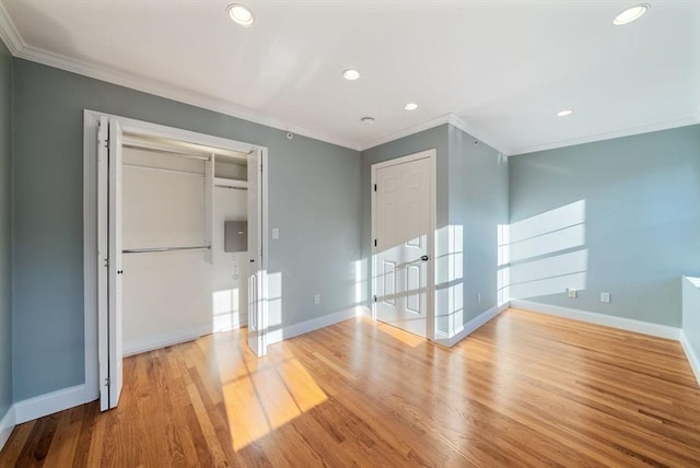 unfurnished room with baseboards, crown molding, and light wood-style floors