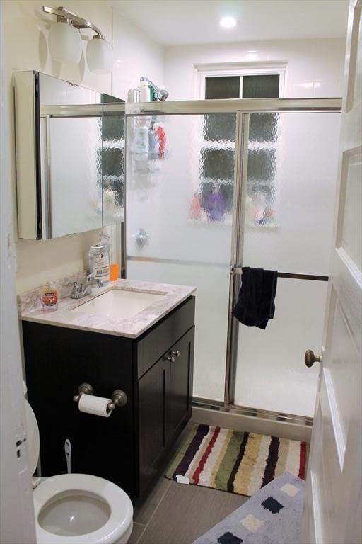 bathroom featuring a stall shower, tile patterned floors, and vanity