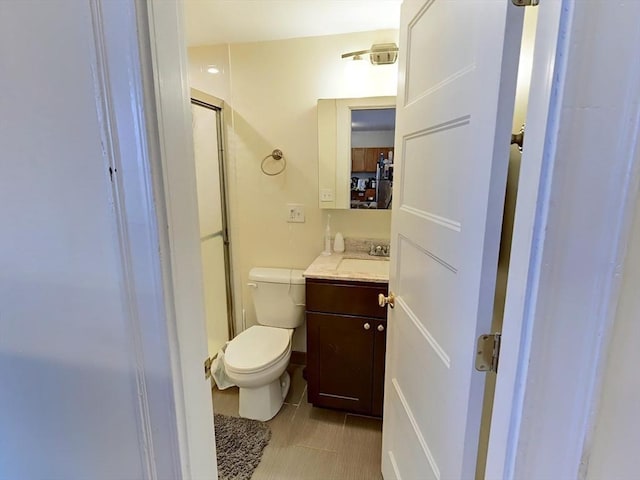 full bath with a stall shower, tile patterned flooring, vanity, and toilet