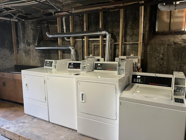 laundry area with washing machine and dryer and wood finished floors