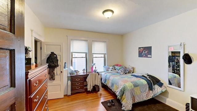 bedroom with light wood-type flooring and baseboards