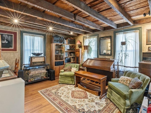 sitting room featuring wood finished floors, beam ceiling, wooden ceiling, and plenty of natural light