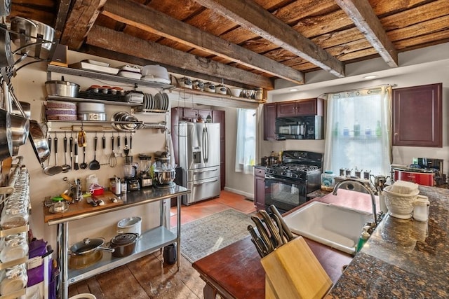 kitchen featuring dark countertops, a sink, black appliances, wooden ceiling, and beam ceiling