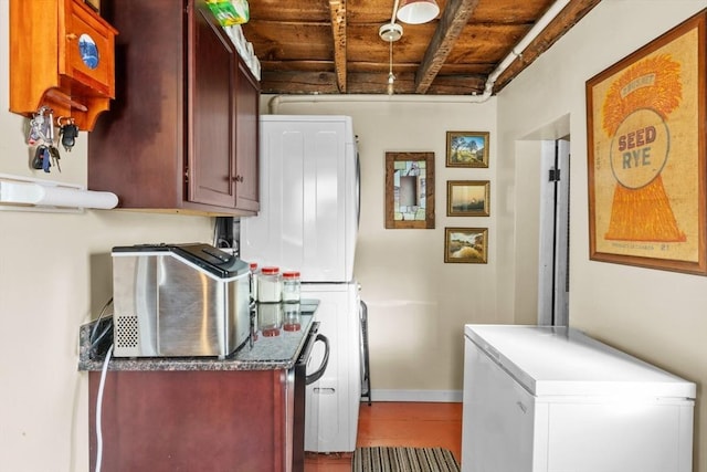 kitchen with baseboards, wood finished floors, and fridge