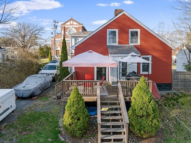 rear view of house with a chimney, stairs, fence, a wooden deck, and brick siding