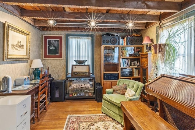 living area featuring beamed ceiling, wood finished floors, and wooden ceiling