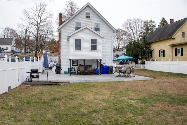 back of property with a yard and a patio