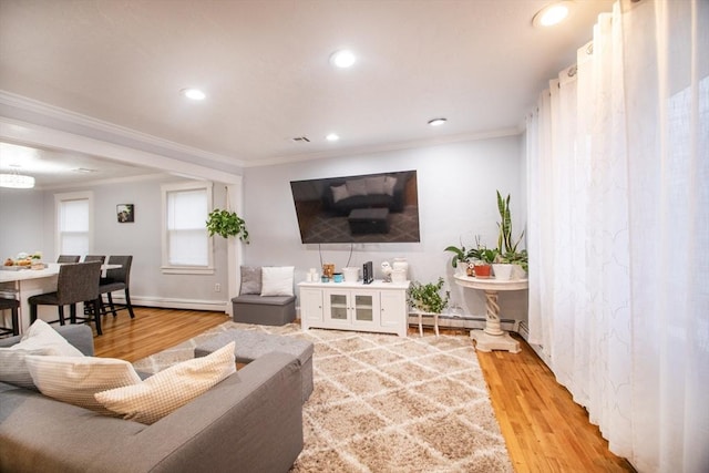 living room with wood-type flooring, baseboard heating, and ornamental molding