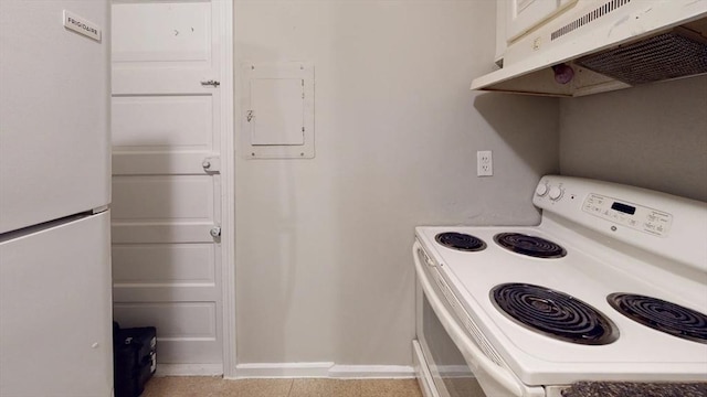 kitchen with white appliances, under cabinet range hood, and baseboards