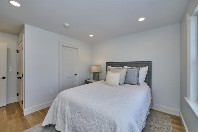 bedroom with baseboards, wood finished floors, and recessed lighting