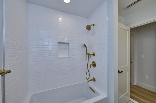 full bathroom featuring  shower combination, visible vents, baseboards, and wood finished floors