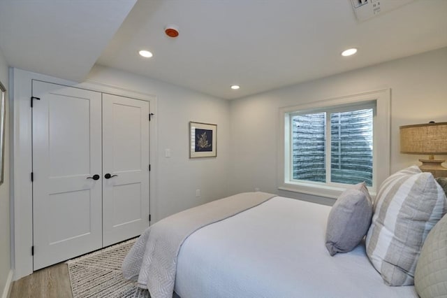 bedroom featuring recessed lighting, a closet, visible vents, and wood finished floors