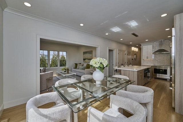 living area featuring recessed lighting, wood finished floors, and crown molding