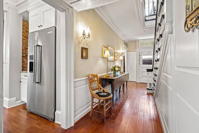 hallway featuring ornamental molding, dark wood finished floors, and a decorative wall