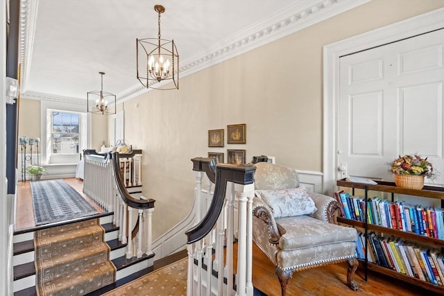 sitting room featuring crown molding, wainscoting, and a chandelier