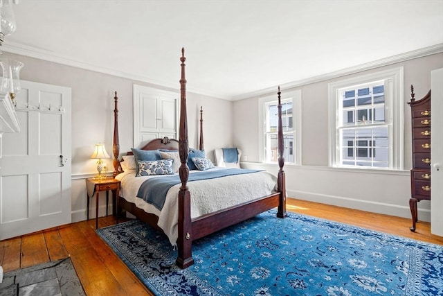 bedroom featuring wood-type flooring, baseboards, and ornamental molding