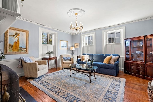 living area with wood-type flooring, baseboards, and an inviting chandelier