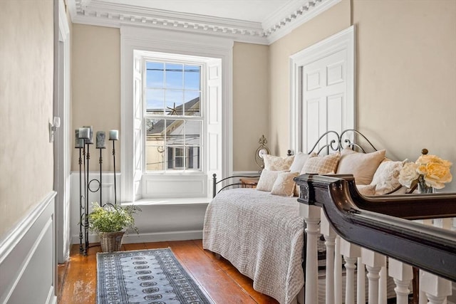 bedroom with crown molding and wood finished floors