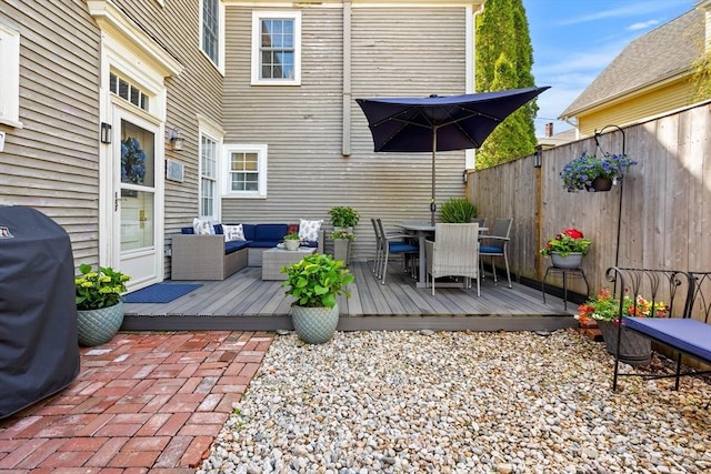 wooden terrace with fence, outdoor dining space, an outdoor living space, and area for grilling