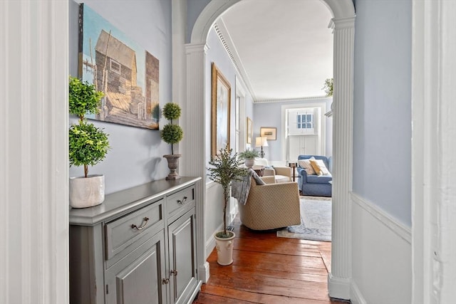 hall featuring ornate columns, arched walkways, and dark wood-type flooring
