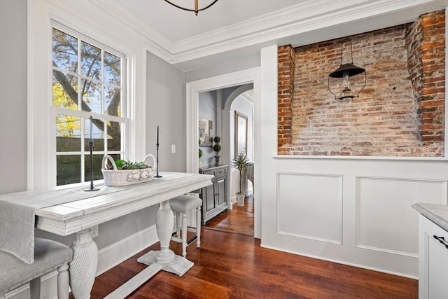 dining area with crown molding, arched walkways, a healthy amount of sunlight, and dark wood-type flooring