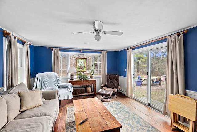 living area with a baseboard radiator, plenty of natural light, and wood-type flooring