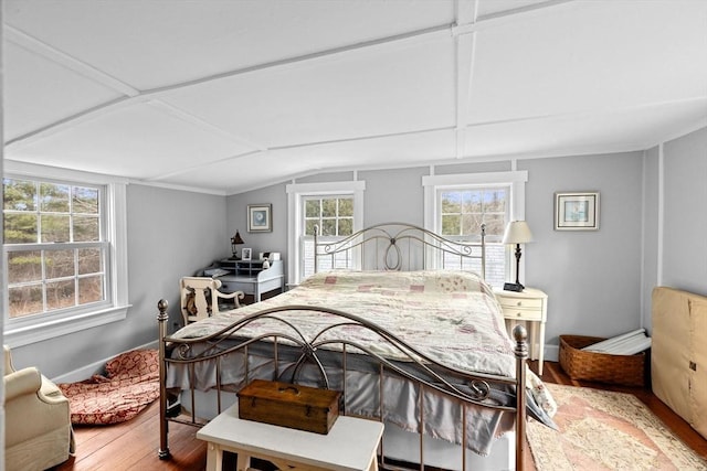 bedroom featuring baseboards, vaulted ceiling, and wood finished floors