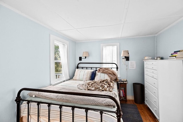bedroom with hardwood / wood-style floors and ornamental molding