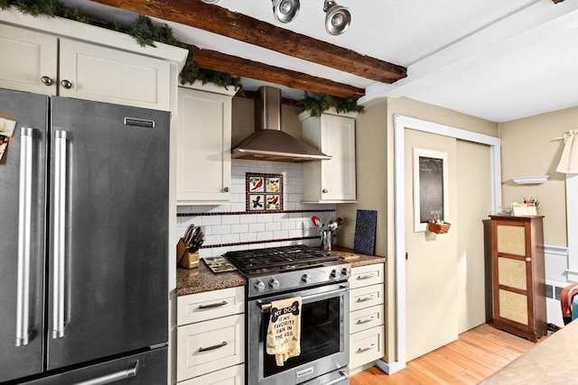 kitchen with stainless steel appliances, backsplash, beam ceiling, light wood-style flooring, and wall chimney exhaust hood