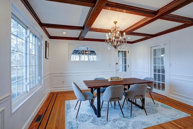 dining room featuring visible vents, coffered ceiling, a healthy amount of sunlight, and beamed ceiling