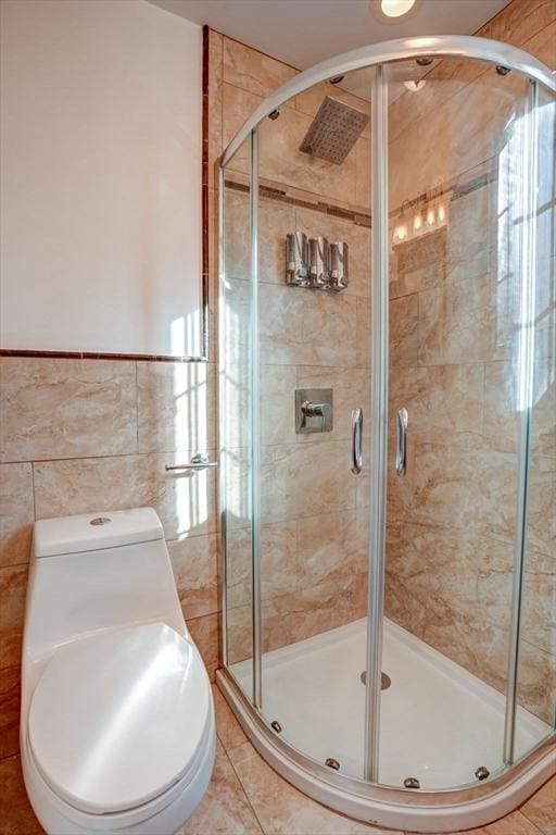 full bathroom with tile walls, a shower stall, and tile patterned flooring