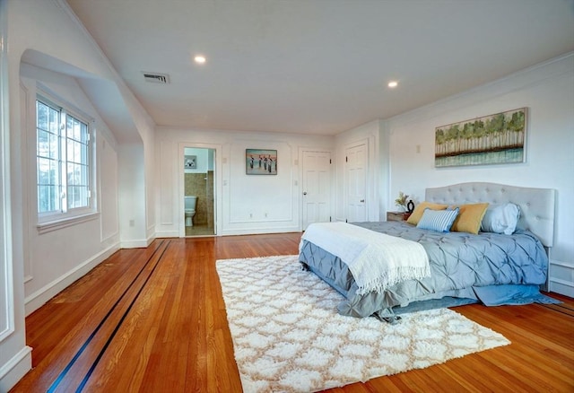 bedroom with recessed lighting, visible vents, connected bathroom, and wood finished floors