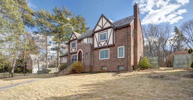 view of front facade featuring stucco siding, brick siding, a chimney, and fence