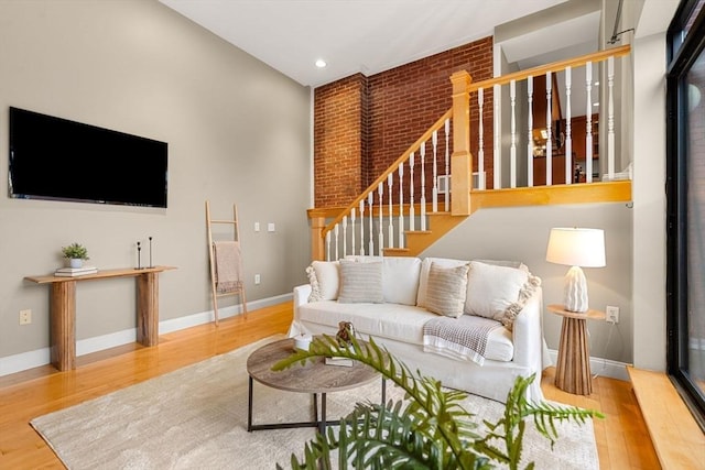 living room featuring light hardwood / wood-style floors and brick wall