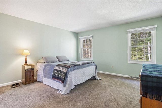 carpeted bedroom with baseboards, visible vents, and multiple windows